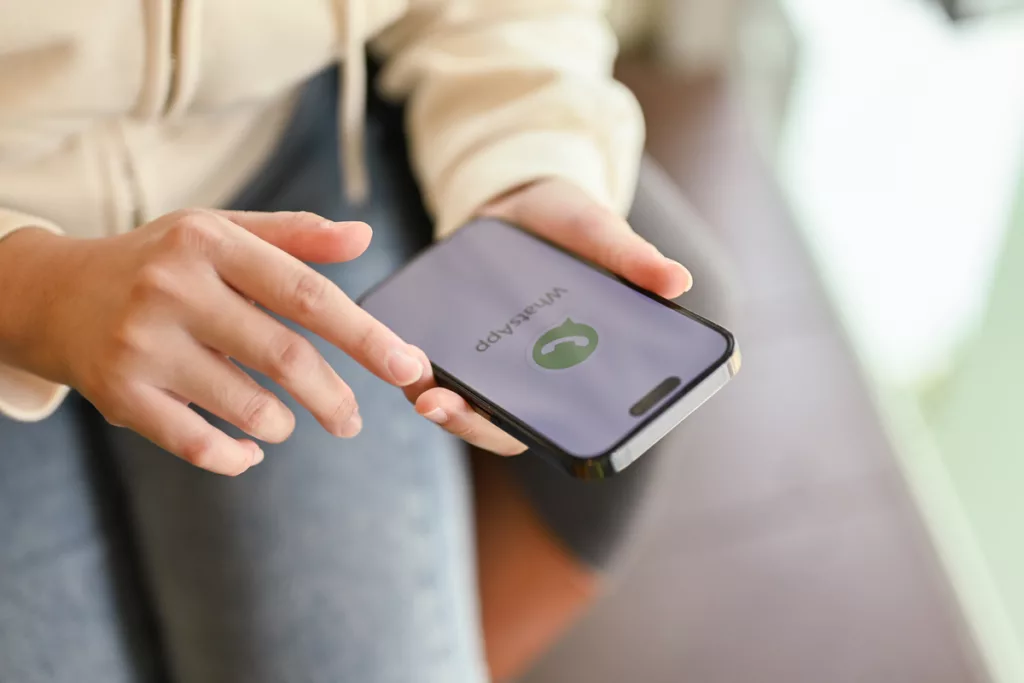 Mulher utiliza o canal de Atendimento via WhatsApp para falar com empresa